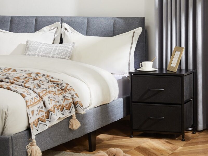 2-drawer nightstand beside the bed with decorative items on top.