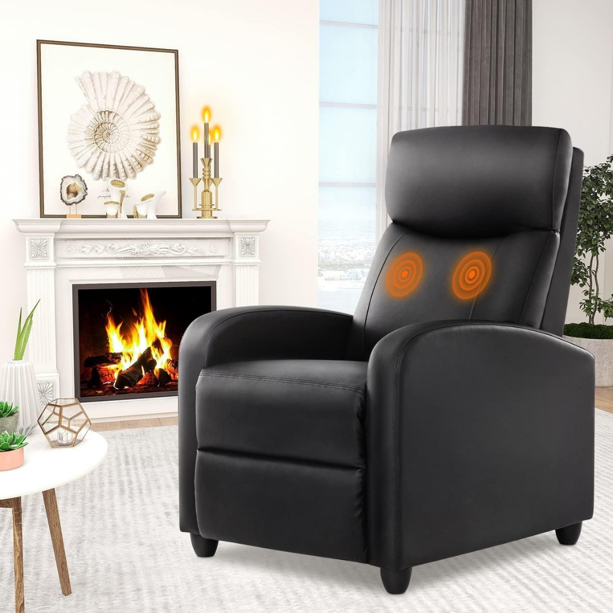 Black massage recliner beside fireplace and round table.